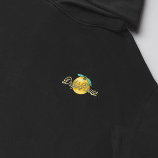 Drift House Fresh Squeezed Hoodie in Vintage Black — relaxed garment-dyed 9.4 oz fleece pullover with Florida orange front graphic, "Fresh Squeezed Threads" back print, drop shoulders, and kangaroo pocket