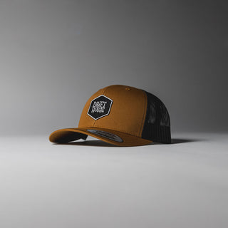 Camel Drift House Hex trucker hat with mesh back and hex logo.