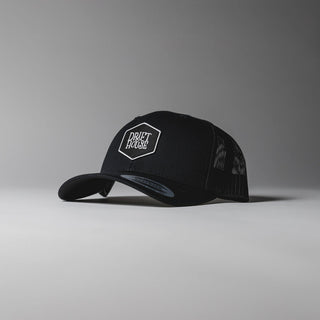Black Drift House Hex trucker hat with mesh back and hex logo.