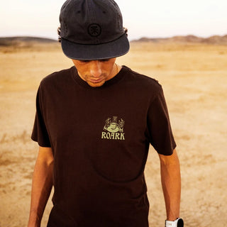 Roark Reading Ritual Premium Tee in Tobacco with a large cream-colored coffee-reading graphic featuring a coffee pot, cup, botanical illustration, and ritual instructions