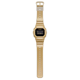G-SHOCK DW5600BEP-9 BlackEyePatch watch with a gold-tone square case and band, black face, digital display, and BlackEyePatch branding