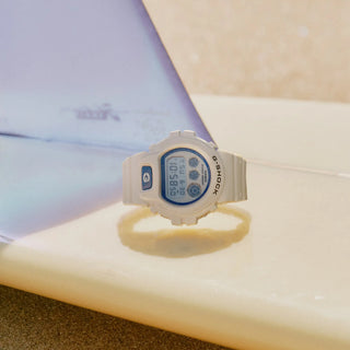 G-SHOCK DW-6900HDS-7 in white with glowing blue face and marine-inspired details.
