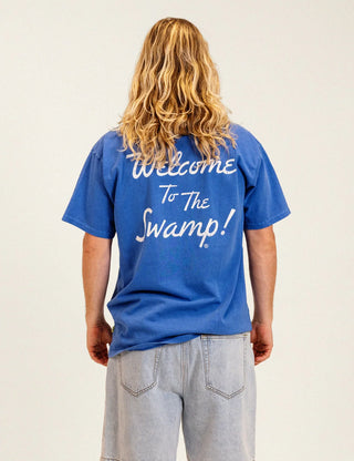 Duvin x Florida Gators Leisure Club Tee with orange Florida lettering and Albert wearing sunglasses and a Hawaiian shirt behind a Leisure Club sign.