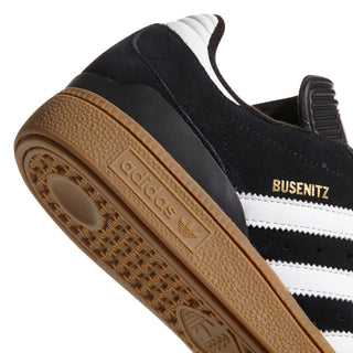 Close-up of a black and white Adidas sneaker with brown sole on a white background