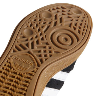 Close-up of an Adidas shoe sole with tread pattern and brand logo.