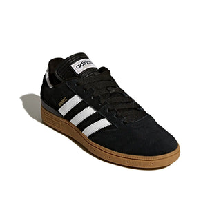 Black Adidas sneaker with white stripes on a light gray background