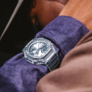 Clear Casio watch on a wrist with a dark background