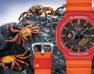 Black and red-orange G-Shock GAB2100DF-4A watch with crab-inspired accents, octagonal case, and Galápagos island dial graphic.