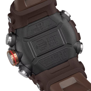 Front view of the G-SHOCK GGB100XMH-5A Mudmaster with a gold-tone bezel, dark brown case and band, black analog-digital dial, and red second hand