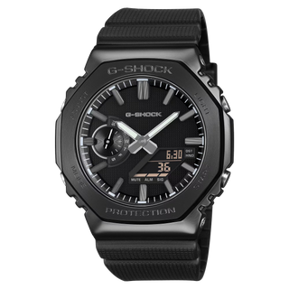 G-SHOCK GM-2100LXB-1A Watch in Black/Gold — CasiOak silhouette with stainless steel case, carbon core guard structure, black IP bezel with gold-tone accents, analog-digital display, 200M water resistant