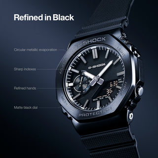 G-SHOCK GM-2100LXB-1A Watch in Black/Gold — CasiOak silhouette with stainless steel case, carbon core guard structure, black IP bezel with gold-tone accents, analog-digital display, 200M water resistant