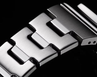 Close-up of a metallic watch strap on a black background