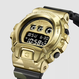 "G-Shock GM6900CMG-3 Bold Camo Gold Watch — gold-colored metal bezel, gold dial, camo printed band with hidden G-mark, classic 6900 silhouette"