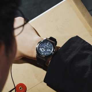 G-SHOCK GSTB1000-2A with a silver-tone metal bezel, blue brick-pattern dial, silver-tone hands and markers, and black band