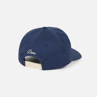 Angled front view of Dime Cursive D Worker Cap in Marine blue with a raised cream embroidered cursive D logo and curved brim