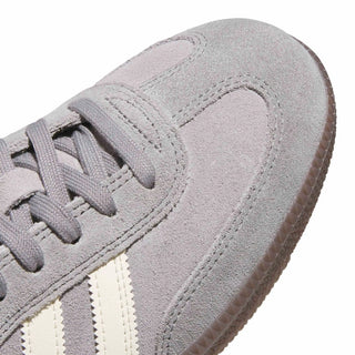 Close-up of a gray Adidas sneaker with white stripes on a white background