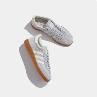 White sneakers with brown soles on a light gray background