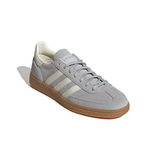 Gray Adidas sneaker with white stripes on a light gray background