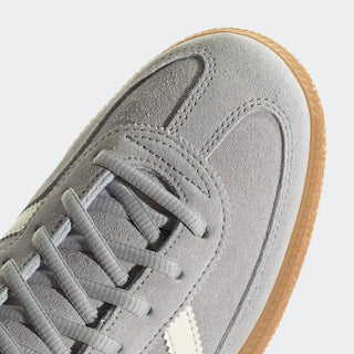 Gray suede sneaker with a brown sole on a light gray background