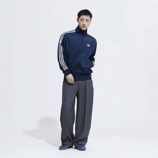 Person wearing a blue tracksuit with white stripes on a white background