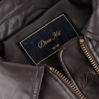 Dime brown quilted jacket with wavy debossed pattern and oversized logo patch.