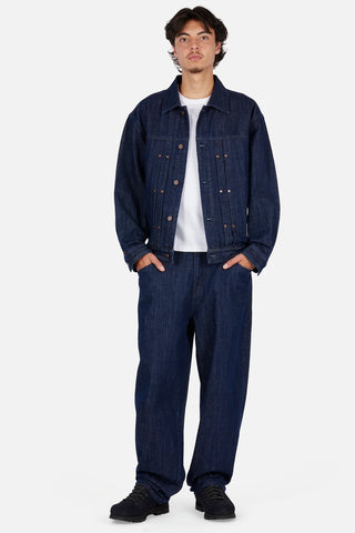 Dime Pleated Denim Jacket in Indigo — 100% cotton with front pleats, custom shanks, hexagon rivets, metal button closure, and woven label branding at hem