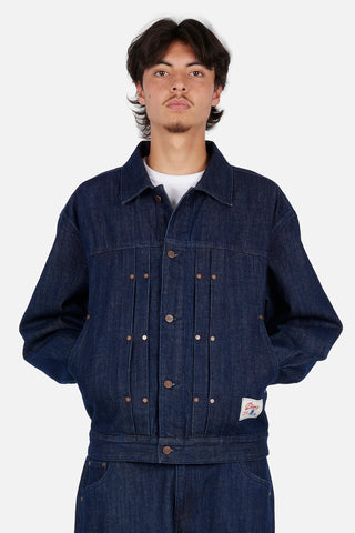 Dime Pleated Denim Jacket in Indigo — 100% cotton with front pleats, custom shanks, hexagon rivets, metal button closure, and woven label branding at hem