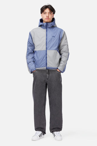 Front view of Dime Reversible Insulated Jacket in Blue Iris with a geometric quilted pattern, hood, zippered pockets, chest logo, and hem cinches