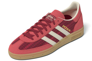 adidas Originals Handball Spezial in Team Victory Red/Off White/Preloved Scarlet — soft suede and textile upper with rubber outsole, lace closure, and Trefoil tongue logo celebrating the iconic 1979 heritage.

