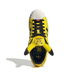 adidas Originals Pokémon Superstar II "Pikachu" in Yellow/Yellow/Core Black — yellow furry upper, Pikachu tail lace jewel, Pikachu ears on tongue, full textile lining and rubber outsole on the classic Superstar II silhouette