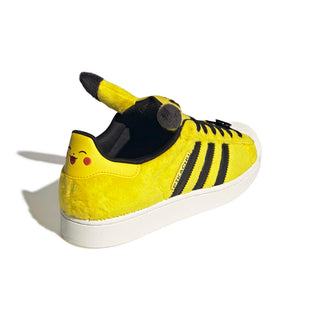 adidas Originals Pokémon Superstar II "Pikachu" in Yellow/Yellow/Core Black — yellow furry upper, Pikachu tail lace jewel, Pikachu ears on tongue, full textile lining and rubber outsole on the classic Superstar II silhouette