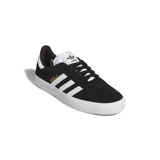 Adidas Gazelle ADV skate shoe in Core Black, Cloud White, and Gold Metallic — low-profile suede upper with cupsole construction and reinforced ollie zone.