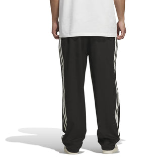 adidas Skateboarding Vintage Superfire Track Pant in Black and Cream White with loose fit and classic track styling.