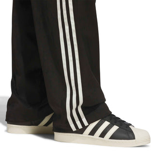 adidas Skateboarding Vintage Superfire Track Pant in Black and Cream White with loose fit and classic track styling.