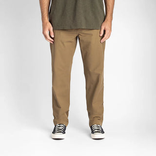 Roark Layover Pro Traveler Pants in Dark Khaki, straight-leg 4-way stretch Embarq Dura-Stretch fabric with TSA-friendly waistband, zippered travel pockets, back phone stash pocket, and laser-perforated cooling panel