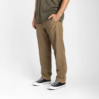 Roark Layover Pro Traveler Pants in Dark Khaki, straight-leg 4-way stretch Embarq Dura-Stretch fabric with TSA-friendly waistband, zippered travel pockets, back phone stash pocket, and laser-perforated cooling panel