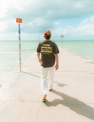 "Duvin x Margaritaville Please Return Tee in Black — relaxed fit beach lifestyle collab tee from Duvin Design Co."