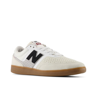 White sneaker with black logo and brown sole on a white background