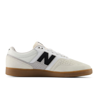 White sneaker with black logo and brown sole on a white background