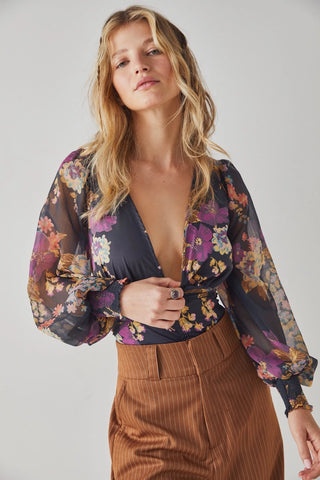 Free People printed bodysuit with deep V-neck, balloon sleeves, and button-front in Black Combo.