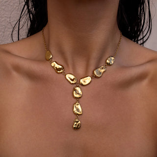 Gold Y necklace with hammered rings and sculpted discs.
