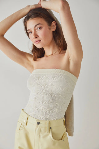 Strapless Free People tube top in ivory with jacquard floral design and lettuce-edge hem.