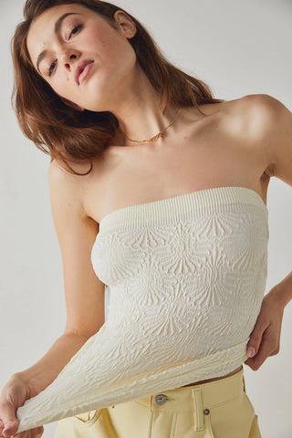 Strapless Free People tube top in ivory with jacquard floral design and lettuce-edge hem.