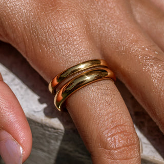 Gold sculptural ring with flowing ocean-inspired curves.