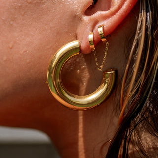 Large polished gold hoop earrings with classic silhouette.