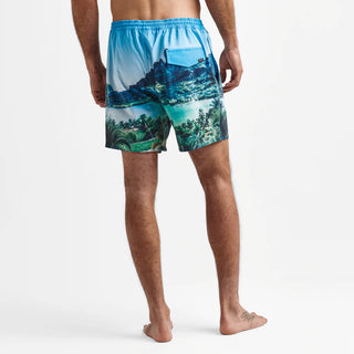 Adventurous individual, immersed in the tropical backdrop of Tahiti, outfitted in the Roark Shorey Boardshorts 16" - Hinano Sun God Light Blue, available at Drift House. These sustainably made, water-resistant, and stretchable boardshorts are inspired by Roark's journey to the heart of Tahiti.