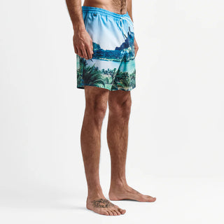 Adventurous individual, immersed in the tropical backdrop of Tahiti, outfitted in the Roark Shorey Boardshorts 16" - Hinano Sun God Light Blue, available at Drift House. These sustainably made, water-resistant, and stretchable boardshorts are inspired by Roark's journey to the heart of Tahiti.