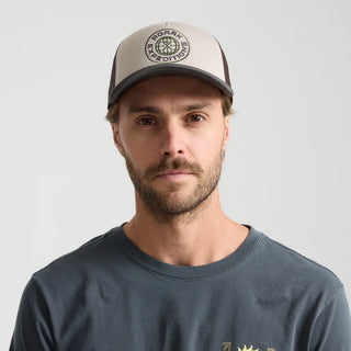 Roark Foam Trucker Global Snapback Hat in Military, structured 5-panel foam front trucker hat in 100% polyester with slightly curved visor, polyester mesh back, snapback closure, contrast visor and mesh color, and satin stitch chain stitch embroidery