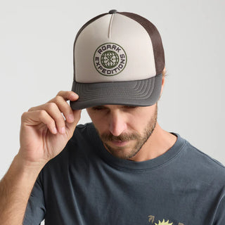 Roark Foam Trucker Global Snapback Hat in Military, structured 5-panel foam front trucker hat in 100% polyester with slightly curved visor, polyester mesh back, snapback closure, contrast visor and mesh color, and satin stitch chain stitch embroidery