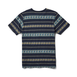 Adventurous man wearing a Roark Revival 'Sunburst Pocket Crew' knit shirt from the Mystic Motu Summer Collection, showcasing its vibrant, sunburst-inspired design and functional pocket.
